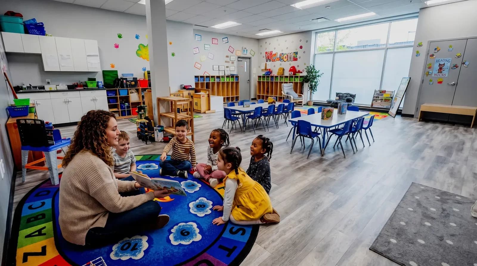 Educator leading circle time with children at Playbox